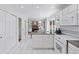 Bright kitchen with white cabinets, granite counters, white appliances, and an island with views into the living room at 3850 S Willow Way, Denver, CO 80237