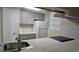 Well-lit kitchen with stainless steel sink, gray cabinets, white appliances, and marble countertops at 12450 E Cornell Ave # 101, Aurora, CO 80014
