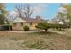 Expansive backyard of a charming brick home with a neatly paved walkway leading to a private, fenced area at 1345 Laredo St, Aurora, CO 80011