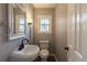 Powder room featuring modern fixtures, pedestal sink, and natural light at 1345 Laredo St, Aurora, CO 80011