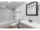 Modern bathroom featuring a tiled shower/tub combination, a vanity with a sink and a decorative mirror at 1345 Laredo St, Aurora, CO 80011