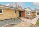 Inviting brick home featuring decorative stone landscaping and a charming covered porch entryway in a quiet neighborhood at 1345 Laredo St, Aurora, CO 80011