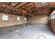 Spacious garage with high ceilings, exposed wooden beams, and concrete flooring, perfect for projects or storage at 1345 Laredo St, Aurora, CO 80011