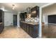 Galley kitchen featuring stainless steel appliances, dark cabinetry, tile backsplash, and access to the living room at 1345 Laredo St, Aurora, CO 80011