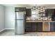 Kitchen featuring stainless steel appliances, dark wood cabinetry, and decorative tile backsplash at 1345 Laredo St, Aurora, CO 80011