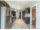 Eat-in kitchen with stainless steel appliances, dark cabinets, tile backsplash, and a view to the living room at 1345 Laredo St, Aurora, CO 80011