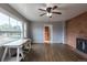 Living room featuring hardwood floors, ceiling fan, a fireplace with brick surround, and a large picture window at 1345 Laredo St, Aurora, CO 80011