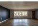 Spacious living room with hardwood floors, a large picture window, and stylish paneled walls at 1345 Laredo St, Aurora, CO 80011