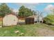 Backyard shed and greenhouse surrounded by green grass at 1345 Laredo St, Aurora, CO 80011