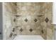 Close-up of tiled shower with built-in shelves and modern fixtures at 1345 Laredo St, Aurora, CO 80011
