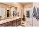 Modern bathroom features a double vanity, walk-in shower with decorative tile, and a neutral color palette at 6045 High Timber Cir, Castle Rock, CO 80104