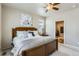 Comfortable bedroom boasts a ceiling fan, large window, and adjoining bathroom showcasing modern design at 6045 High Timber Cir, Castle Rock, CO 80104