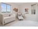 Comfortable Bedroom with a crib, chair, books and great natural lighting at 3056 Yale Dr, Broomfield, CO 80023