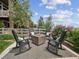 Outdoor seating area with a fire pit, comfortable seating and a decorative rug at 3056 Yale Dr, Broomfield, CO 80023
