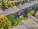 An aerial view of townhomes featuring well-kept lawns, fenced yards, and beautiful landscaping with mature trees at 6135 S Paris St, Englewood, CO 80111