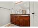 Bathroom featuring a double vanity with granite countertop and a view of the walk-in shower at 6135 S Paris St, Englewood, CO 80111