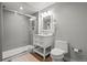 Modern bathroom featuring a glass shower enclosure, a white vanity with storage, and wood flooring at 6135 S Paris St, Englewood, CO 80111