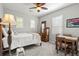 Bedroom featuring a twin bed, chair, desk, ceiling fan, and plantation shutters at 6135 S Paris St, Englewood, CO 80111