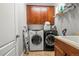 Functional laundry room with front load washer and dryer and upper cabinets at 6135 S Paris St, Englewood, CO 80111