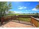 Wooden deck overlooking the green grass and trees with clear, bright sky in background at 9740 W 104Th Dr, Westminster, CO 80021