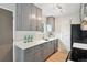 Modern kitchen with quartz counters, grey cabinets, updated appliances, and wood flooring at 9740 W 104Th Dr, Westminster, CO 80021