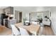 Open layout with kitchen and dining space featuring a modern table, neutral color scheme, and living room at 9740 W 104Th Dr, Westminster, CO 80021