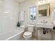 Clean bathroom with subway tile, pedestal sink, and bathtub at 5022 E 17Th Ave, Denver, CO 80220