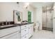 Modern bathroom with double vanity, glass shower, and patterned floor at 5022 E 17Th Ave, Denver, CO 80220