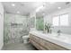 Bathroom with walk-in shower with marble surround and floating vanity at 6088 S Lakeview St, Littleton, CO 80120