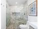 Walk-in shower features pebble floor, marble surround, and frameless glass at 6088 S Lakeview St, Littleton, CO 80120
