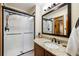 Bathroom with a glass-enclosed shower and a vanity featuring a stone countertop and modern fixtures at 50 Deerwood Dr, Littleton, CO 80127