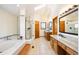 Bright bathroom offering a walk-in shower, separate vanities, and tile flooring at 50 Deerwood Dr, Littleton, CO 80127