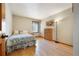A cozy bedroom featuring wood floors, a window, and a chest of drawers at 50 Deerwood Dr, Littleton, CO 80127