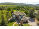 Aerial view of a beautiful home showcasing landscaped grounds, mature trees, and stunning mountain views at 50 Deerwood Dr, Littleton, CO 80127