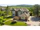 View of a two-story home featuring brick and grey trim, landscaped yard and a mountain view at 50 Deerwood Dr, Littleton, CO 80127