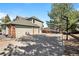 Home featuring a three-car garage, basketball hoop, and lush landscaping at 50 Deerwood Dr, Littleton, CO 80127