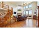 Inviting living room featuring a cozy fireplace, soaring ceilings, hardwood floors, and a staircase at 50 Deerwood Dr, Littleton, CO 80127