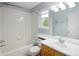 Bright bathroom featuring a tub and shower combination, single sink vanity, and a large window, blending comfort and functionality at 1885 S Quebec Way # M101, Denver, CO 80231