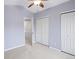 Bedroom featuring a light purple color scheme, large closets, carpeted floors, and natural light from the entry doorway at 1885 S Quebec Way # M101, Denver, CO 80231
