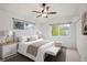 Inviting main bedroom featuring neutral tones, with plush bed, ceiling fan, and abundant natural light from two windows at 1885 S Quebec Way # M101, Denver, CO 80231