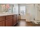 Beautiful bathroom with wood-look floors, double vanity, a walk-in shower, and modern fixtures at 6491 N Danube St, Denver, CO 80249