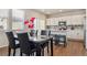 Inviting dining area with wood floors, table with six chairs, and view of kitchen at 6491 N Danube St, Denver, CO 80249