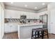 Well-lit kitchen featuring white cabinets, stainless steel appliances, and breakfast bar at 6491 N Danube St, Denver, CO 80249