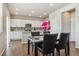Modern kitchen with white cabinets, stainless steel appliances, and dining area at 6491 N Danube St, Denver, CO 80249