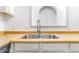 Close-up of a stainless steel kitchen sink with a modern faucet and butcher block countertops at 540 Hickory St, Hudson, CO 80642