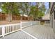 Cozy backyard deck with white railings, shaded by mature trees, offering a tranquil outdoor space at 18121 E Adriatic, Aurora, CO 80013