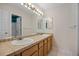 Well-lit bathroom features dual sinks, a large mirror, ample cabinet space and a tile countertop at 18121 E Adriatic, Aurora, CO 80013
