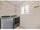 Convenient laundry room equipped with a modern washer and dryer and shelving at 18121 E Adriatic, Aurora, CO 80013