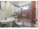 Bathroom featuring a pedestal sink, a tiled shower with a glass door, and updated fixtures at 335 N 16Th Ave, Brighton, CO 80601