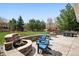 Outdoor patio with a stone fire pit, blue Adirondack chairs, and dining set at 5207 Denim Ct, Parker, CO 80134